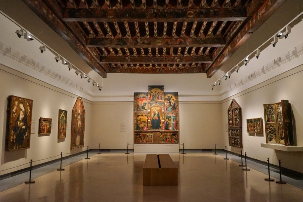 Religious paintings beneath a wooden ceiling in the Prado Museum