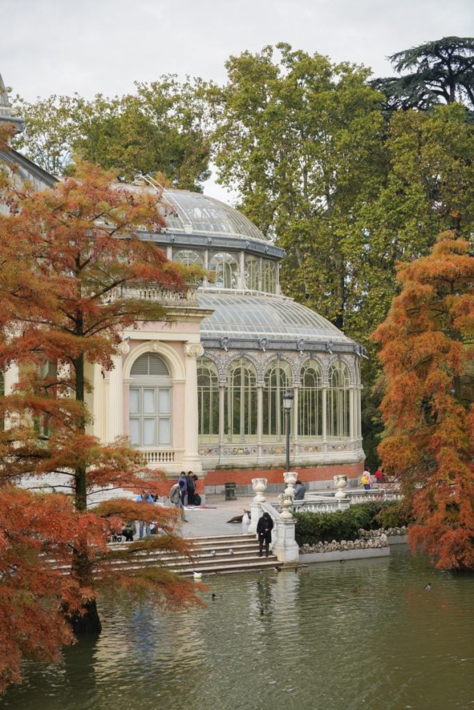 Palacio de Cristal beside a pond and autumn-colored trees