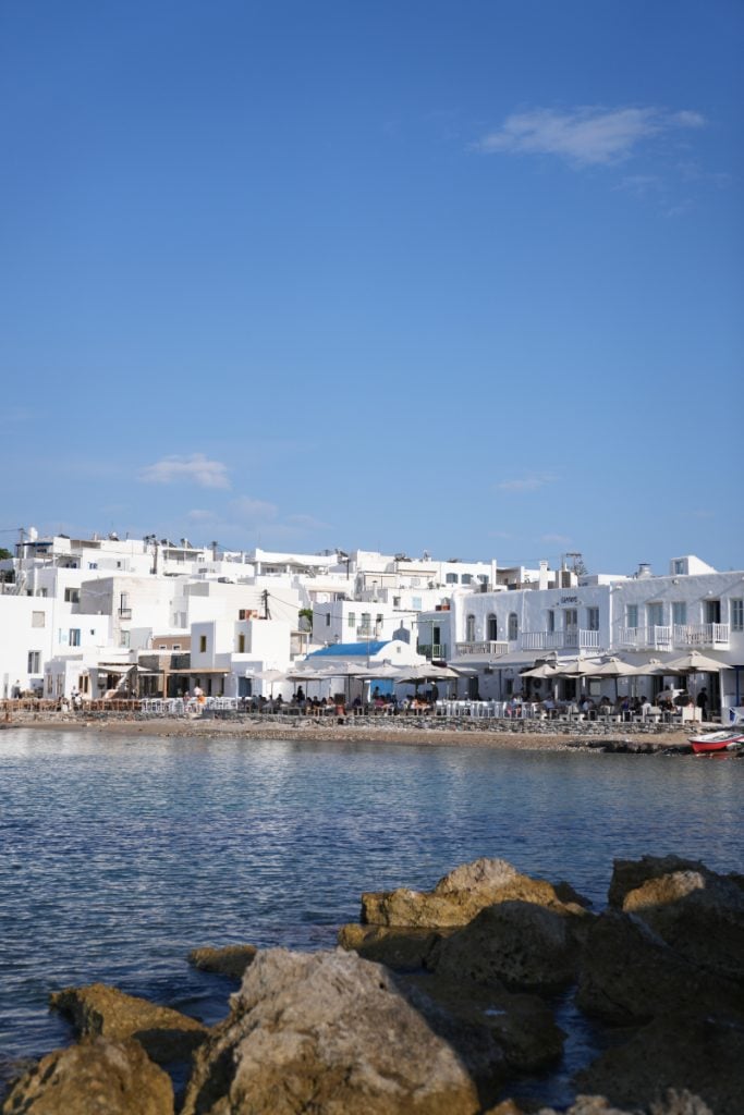 Whitewashed waterfront restaurants across a bay in Paros