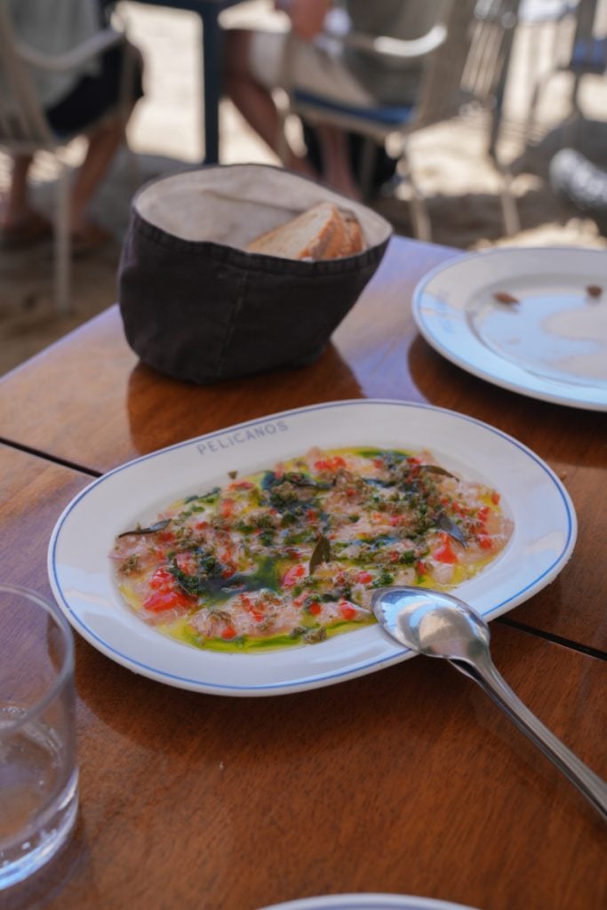 Fish crudo with herbs and colorful garnishes at Pelicanos