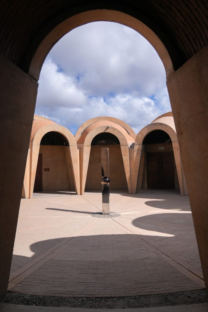 Arched courtyard and sculpture at Pictograma Vinícola