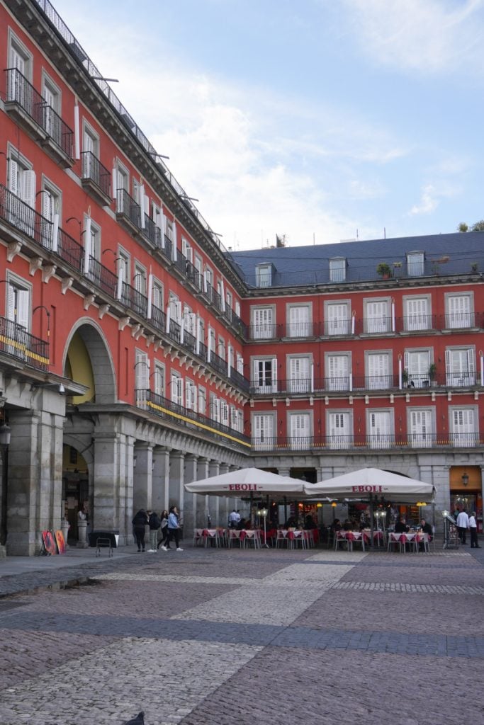 Red façades and café tables in Madrid’s Plaza Mayor