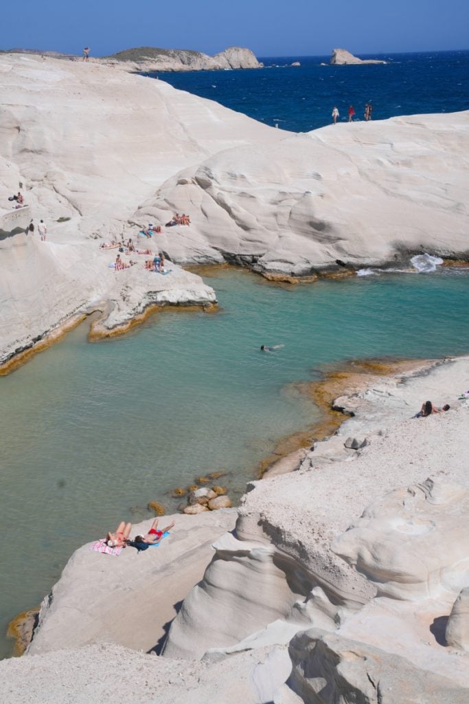 Swimmers among white volcanic rocks at Sarakiniko Beach