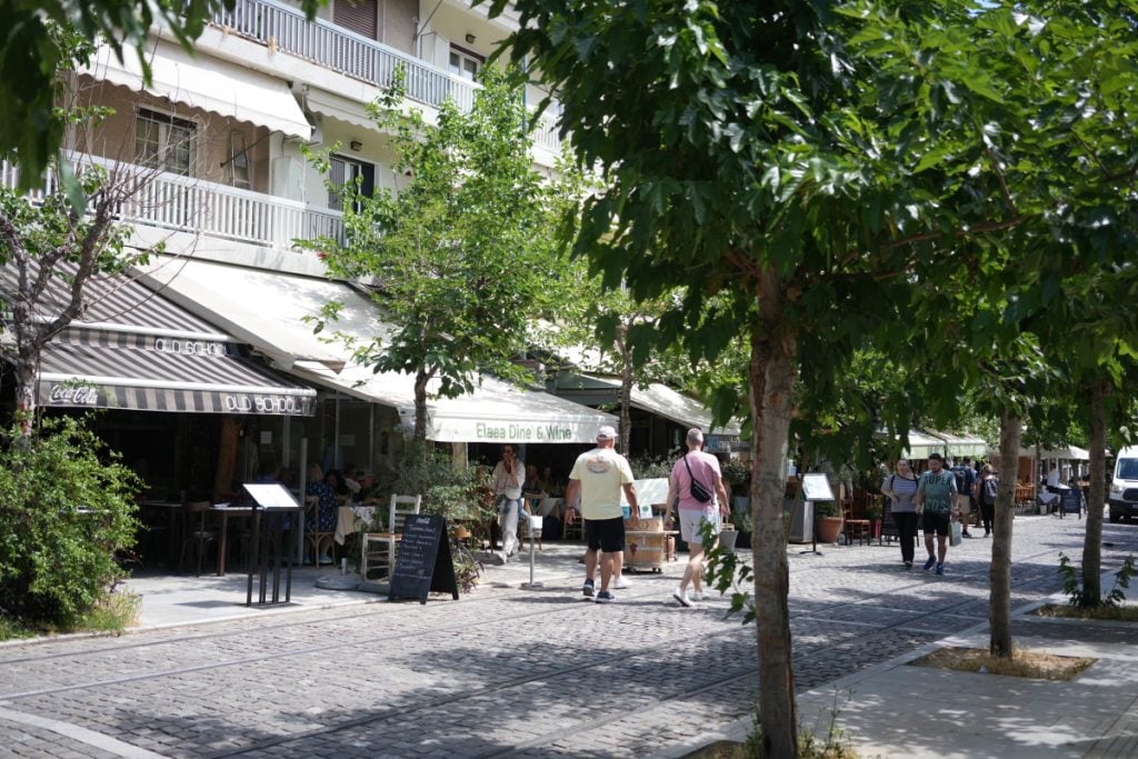 Tree-lined Athens street with sidewalk cafés and pedestrians