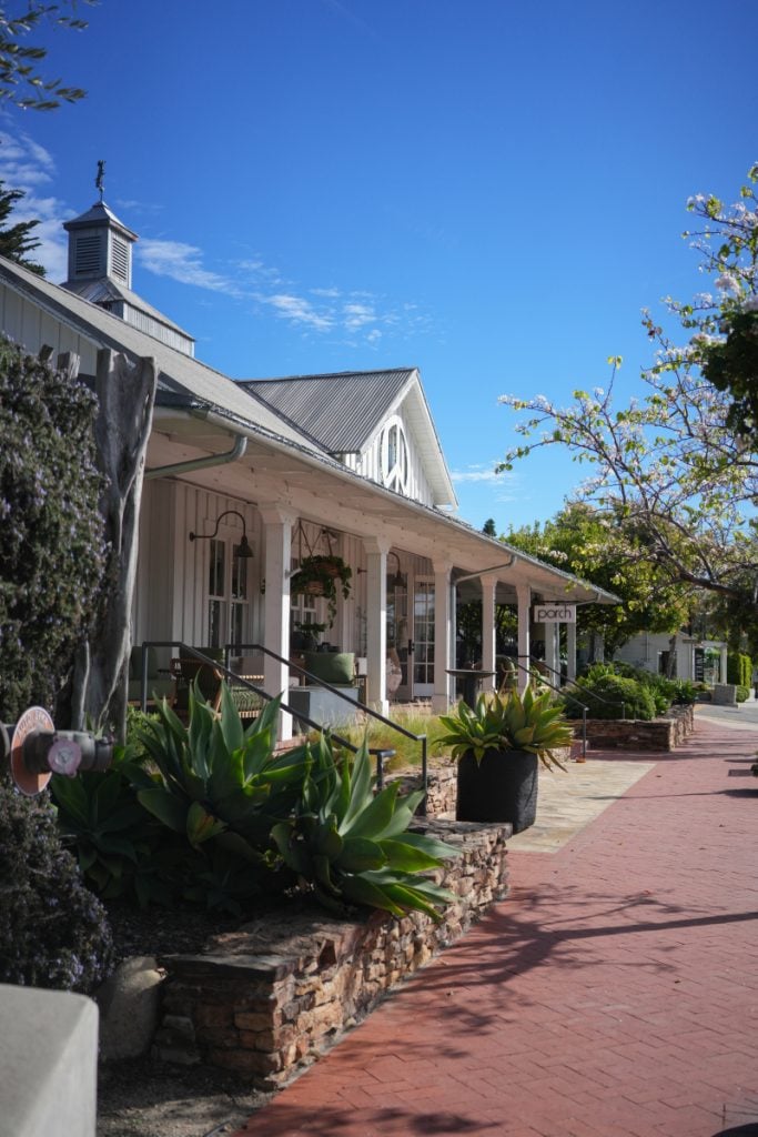 Porch storefront beside a brick sidewalk and succulent planters in Summerland