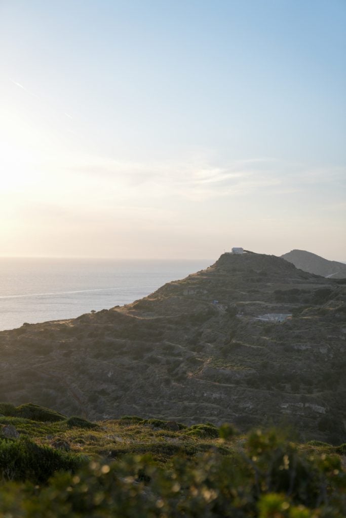 Sunset over the sea and coastal hills in Milos