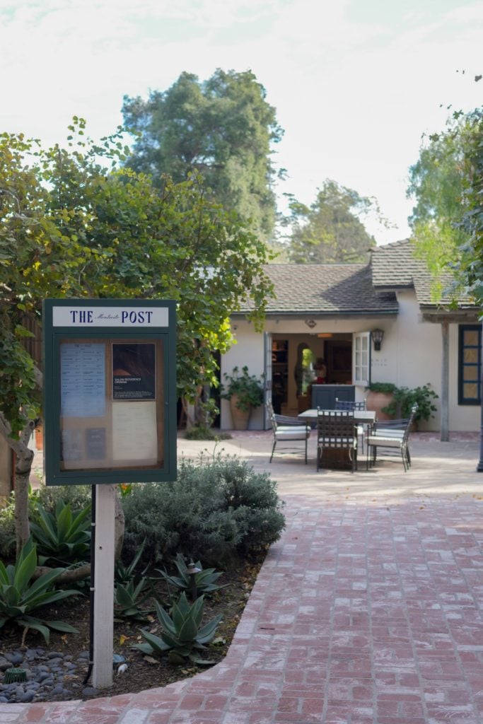 The Post Montecito directory sign beside a brick path into the shopping courtyard