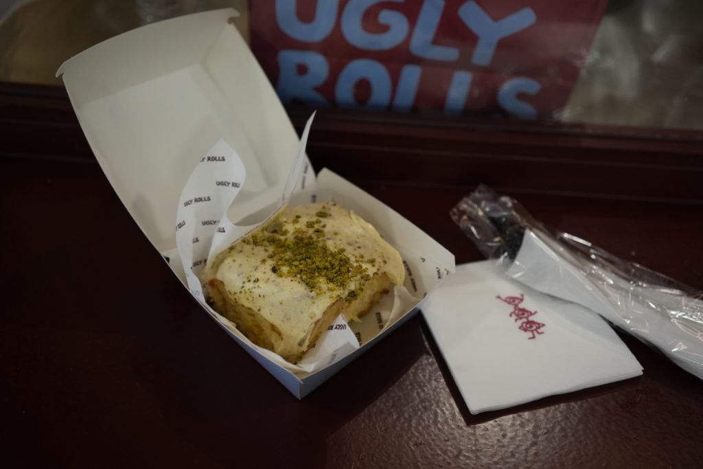 Pistachio cinnamon roll in an Ugly Rolls box